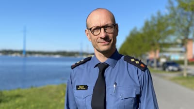 En man klädd i blå uniform framför ett blått av.