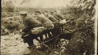 Soldater som sitter på en fälttoalett under första världskriget.