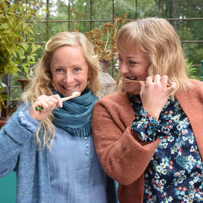 Strömsös programledare Alexandra De Paoli och Elin Skagersten-Ström står med varsin tandborste och tittar leende in i kameran.