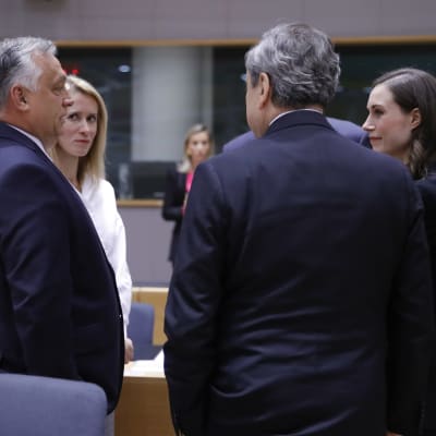 Viktor Orbán, Kaja kallas, Mario Draghi och Sanna Marin står i en cirkel och talar med varandra.