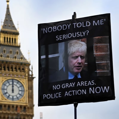 Protestoijan kyltti Boris Johnsonin vastaan ja taustalla näkyy Big Ben.