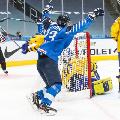 Två finländska spelare firar ett mål vid Sveriges kasse.