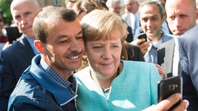 Angela Merkel tar en selfie med en flykting