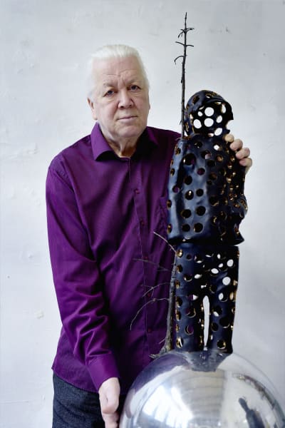 Pekka Kauhanen tillsammans med en miniatyrversion av skulpturen "Valon tuoja".