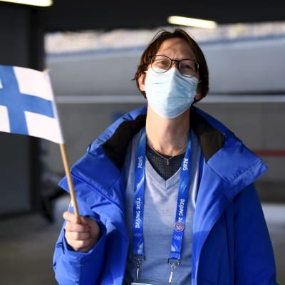 Sari Essayah viftar med Finlands flagga.
