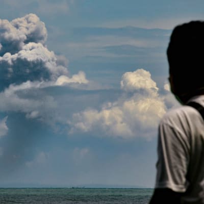 En man tittar på askmolnet från vulkanen Anak Krakatau på ön med samma namn. Bilden är tagen från Serang, öster om Jakarta på lördagen. 