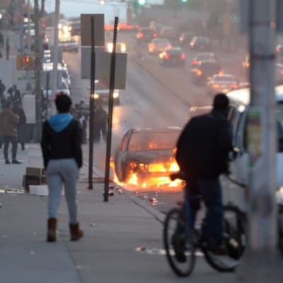En bil brinner på en gata i Baltimore.