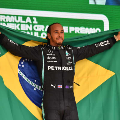 Lewis Hamilton poserar med den brasilianska flaggan.