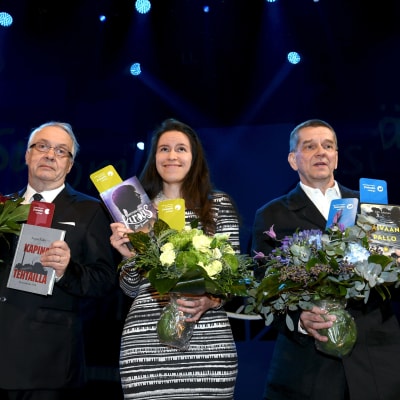 Seppo Aalto, Siiri Enoranta och Olli Jalonen står på rad med blommor och sina vinnande verk i handen. 