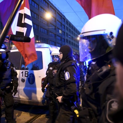 Demonstranter med nazistflaggor och poliser.