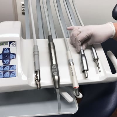 Fem olika instrument, bland annat skaften till borrar, på en bricka hos tandläkaren. 