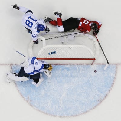 Jonathan Toews försöker få in pucken bakom Tuukka Rask.