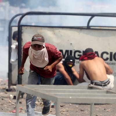 Civila slåss mot Venezuelas polis som inte släpper in transporter via bron  Simón Bolívar  i Cúcuta, Colombia, 23.2.2019