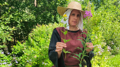 En kvinna håller upp två växter.