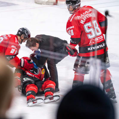 En liggande Otto Kivenmäki får vård på isen.