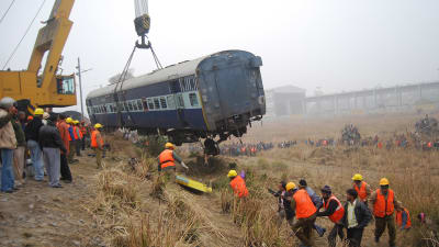 Hjälparbetare röjer undan och räddar överlevande efter en tågolycka nära staden Kanpur i Indien i januari 2010.