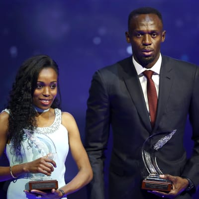 Almaz Ayana och Usain Bolt håller upp sina priser.
