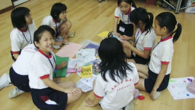 En grupp barn i Kina gör uppgifter på skolgolvet. 