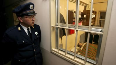 En japansk fångvaktare tittar in i en cell i ett fängelse i Toyama, i centrala Japan. Bilden är en arkivbild från 2006.
