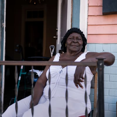 86-åriga Symentress Calloway sitter på balkongen till sin bostad i New Orleans.