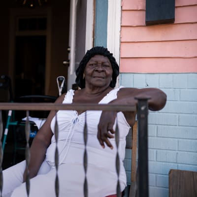 86-åriga Symentress Calloway sitter på balkongen till sin bostad i New Orleans.