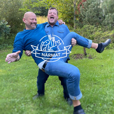 Två personer står och skrattar på en gräsmatta
