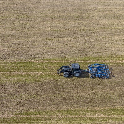 Traktori ajaa pellolla.