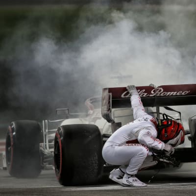 Kimi Räikkönen inspekterar sin bil.