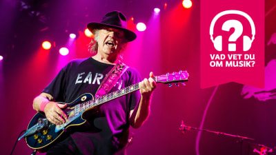 Neil Young har hatt på huvudet och han spelar elgitarr.