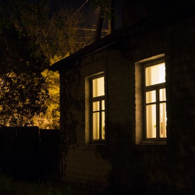Upplysta fönster i hus på natten