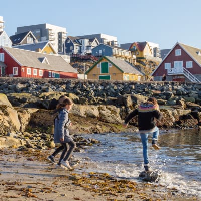 Lapset leikkivät rannalla Grönlannin Nuukissa