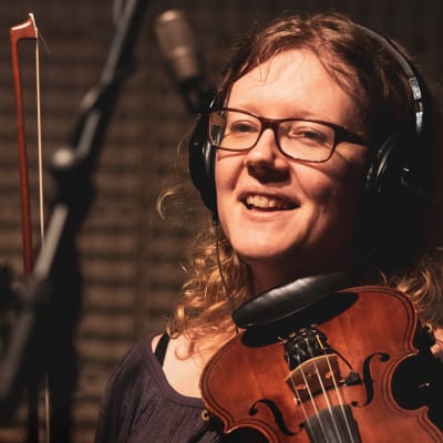 Johanna Lönngren med violin och stråke i inspelningsstudio. 