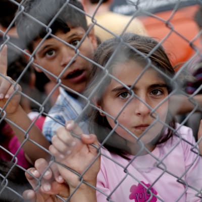Syriska flyktingbarn bakom ett stängsel i flyktinglägret distriktet Nizip i Turkiet 2016.