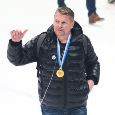 Pekka Virta ger tummen upp med en guldmedalj runt nacken.