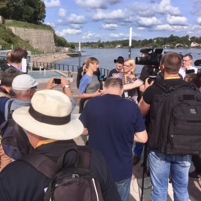 Estlands president talar med media vid Narvafloden.