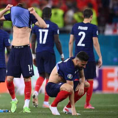 Franska fotbollspelare deppar efter matchen, Spelare med nummer 14 drar tröjan över huvudet.