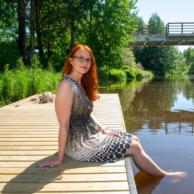 Työterveyspsykologi Mari Laari istuu Kerava-joen laiturilla.