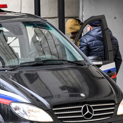 Evan Gershkovichia saatetaan viranomaisautoon. 