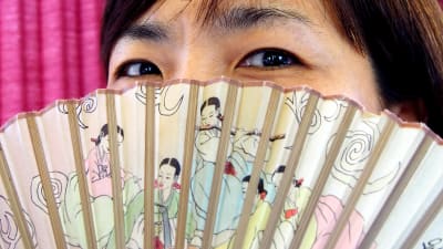 Koreansk kvinna med solfjäder.