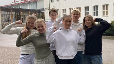 Fem elever och en lärare ser arga in i kameran