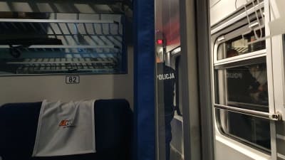 Polisen förhör en passagerare på ett tåg i Polen