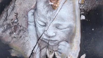 En nyfödd bebis målad på klippor