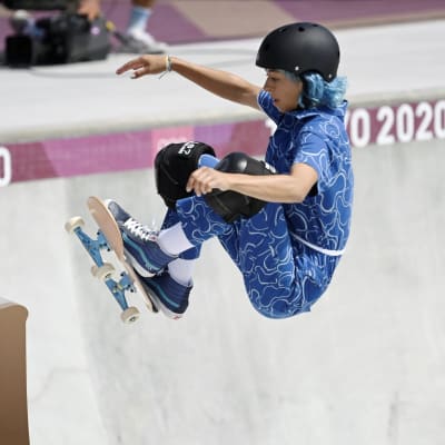 Skateboardare i blå dräkt under sitt åk.
