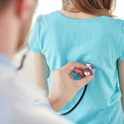 Läkare undersöker ett barn med stetoskop.