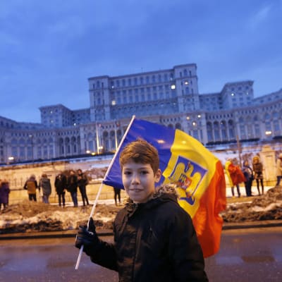 Pojke med rumänsk flagga deltar i protesterna mot det planerade korruptionsdekretet framför parlamentet i Bukarest.