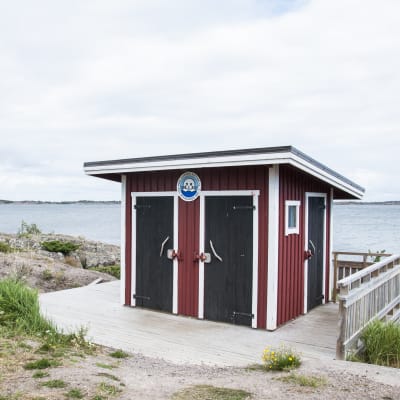 Rödmålat utedass i skärgården