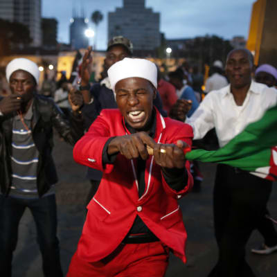 Personer som stöder den sittande presidenten Uhuru Kenyatta jublar och viftar på en flagga i Nairobi medan de väntar att valkommissionen ska bekräfta resultatet i det kenyanska presidentvalet 2017.