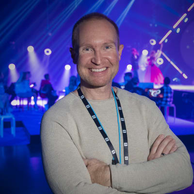 Sångcoachen Tomas Höglund poserar framför MGP-scenen.