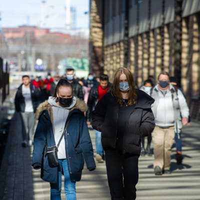 Resenärer med munskydd på perrongen vid Helsingfors järnvägsstation.