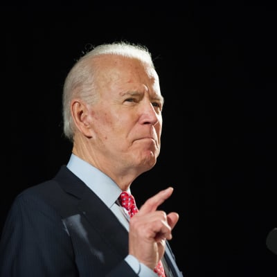 Joe Biden pekar i luften med sitt pekfinger i en talarstol.